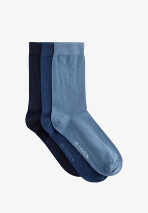 Drei Paar gefaltete Knöchelsocken in Hellblau, Mittelblau und Dunkelblau, jeweils mit dem Text "WE FASHION" auf der Sohle.