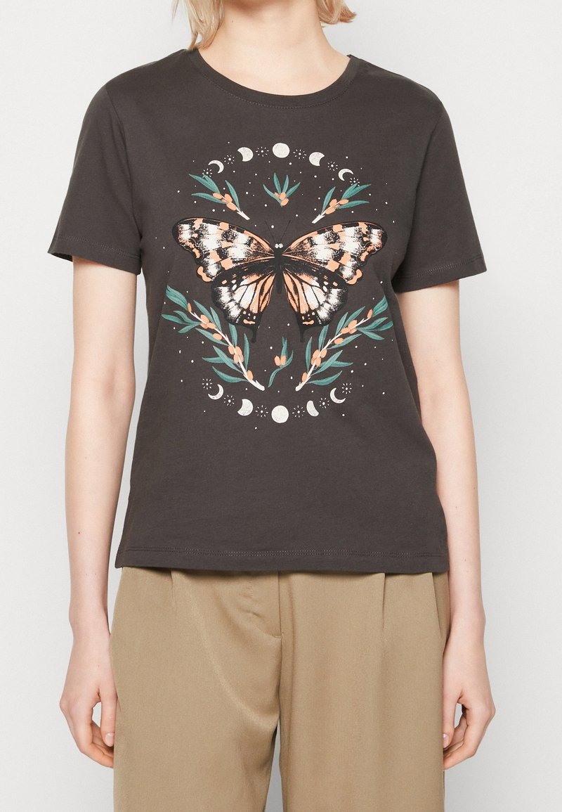 Chemise noire à manches courtes avec un grand motif papillon, entourée de phases lunaires et de branches feuillues vertes avec de petites baies orange.
