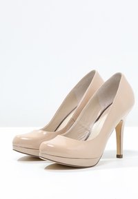 Beige lackläder högklackade skor med rundade tår, en plattformssula och en smal stilettklack. Slät och glansig yta.