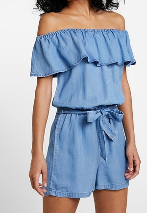 Lichtblauwe denim romper met off-shoulder ontwerp, ruches bij de hals, elastische tailleband en strikceintuur. Heeft een casual pasvorm met shorts.
