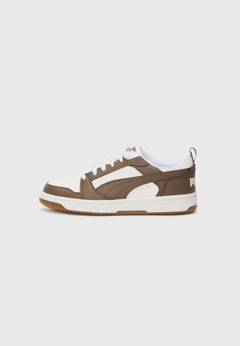 Brune og hvide sneakers med syntetisk overdel, perforeret tå og gummisål. Har snørebånd og et logoakcent på hælen.