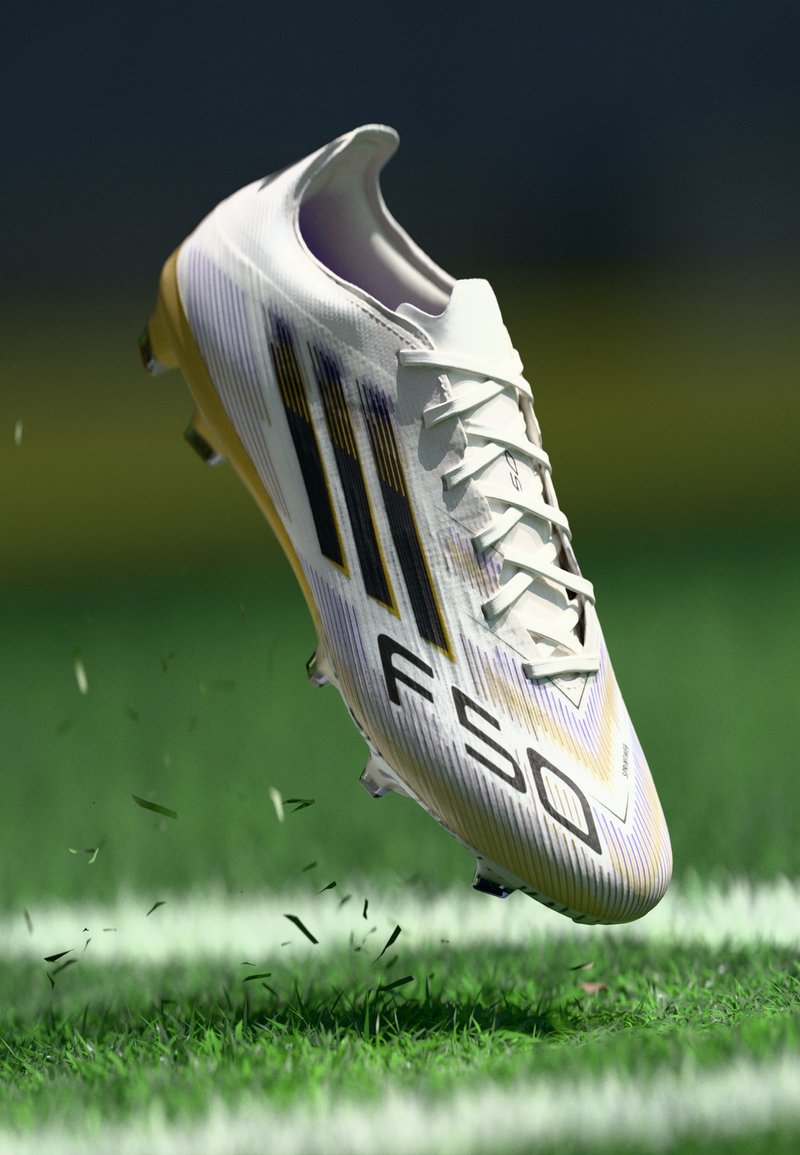 Football boot with a primarily white synthetic upper, featuring purple and black accents and a textured finish. Cleats designed for grass.