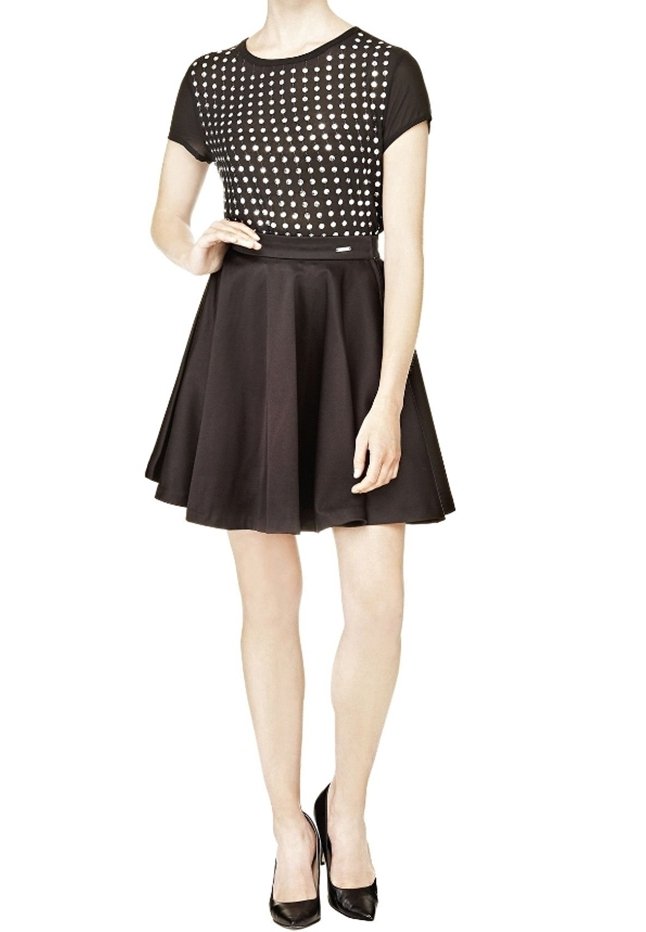 Vestido negro con un top ajustado y tachonado y una falda acampanada. Mangas cortas, tejido suave y una cintura definida.