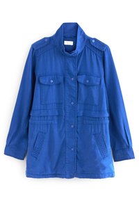 Chaqueta ligera azul con cuello alto, cierre de botones, dos bolsillos en el pecho y parches texturizados en los costados. Hecha de una tela suave.