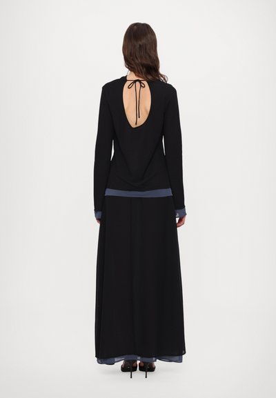 Black long-sleeve dress with open back, tied neck closure, layered design, and blue accents at sleeves and hem. Smooth texture.