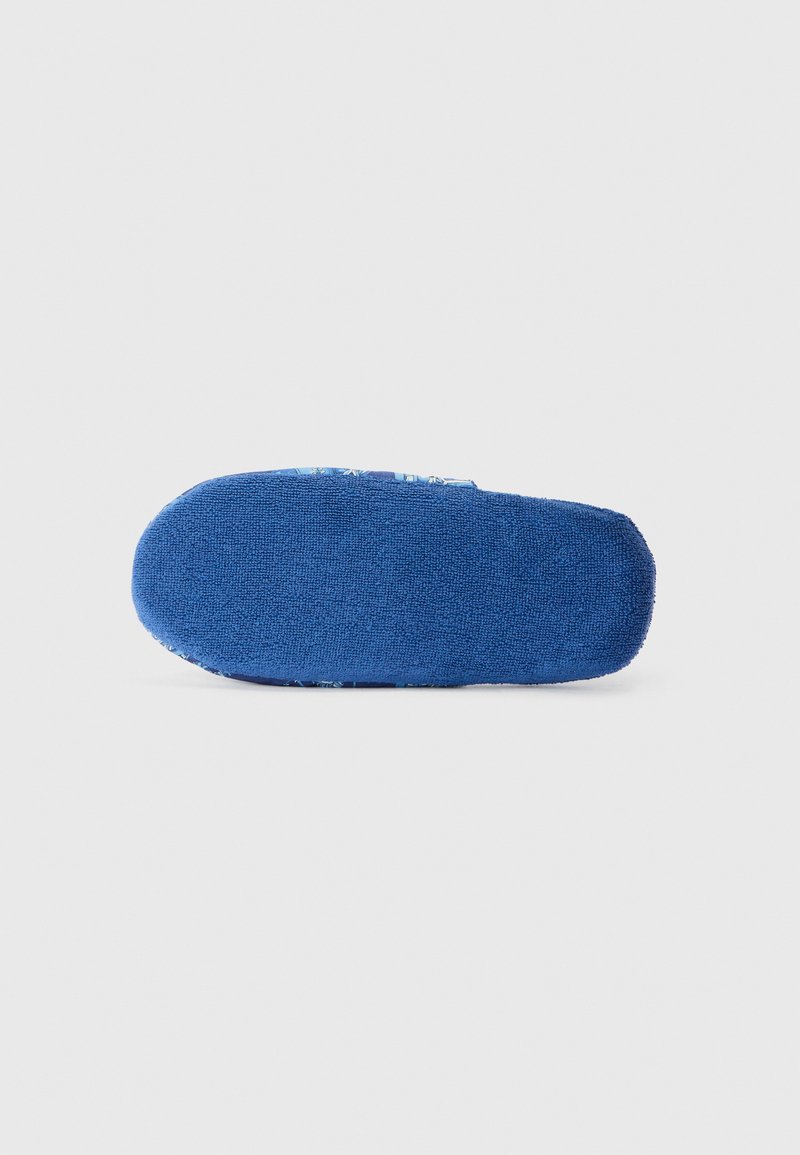 Blaue Hausschuhsohle mit strukturierter Oberfläche. Die Sohle besteht aus einem weichen, plüschigen Material und hat eine gebogene Kante für Komfort und besseren Halt.