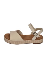 Beige espadrillesandal med en vevd jutesåle, bred kryssremdesign, justerbar ankelrem og en myk semsket føtt.