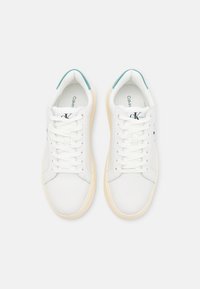 Witte leren sneakers met een ronde neus, witte veters en teal accenten op de hiel. Lichtgekleurde rubberen zool met een gematteerde afwerking.