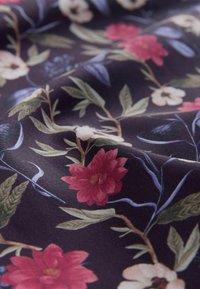 Bloemstof met een donkere achtergrond en roze en witte bloemen, groene bladeren en delicate blauwe wijnstokken. Zachte textuur.
