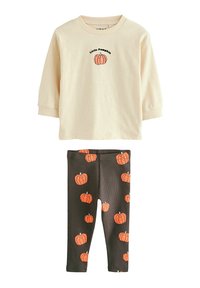 Beige pitkähihainen paita, jossa on "Little Pumpkin" -grafiikka, yhdistetty tummiin legginsseihin, joissa on oransseja kurpitsakuvioita. Puuvillasekoitemateriaali.