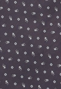 Granatowa tkanina o subtelnej fakturze, z rozrzuconymi białymi motywami kwiatowymi i okrągłymi. Wzory są równomiernie rozmieszczone na powierzchni.