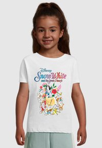 Hvid bomulds t-shirt med et farverigt print af Snehvide omgivet af syv dværge og blomsterdetaljer. Rund hals, korte ærmer.