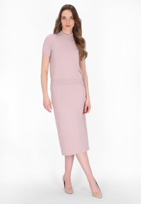 Knee-length, upnuté šaty v jemně růžovém materiálu s krátkými rukávy a kulatým výstřihem. Hladká textura, minimalistický design a subtilní elegance.