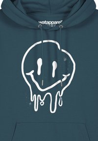 Petrolblauwe hoodie met een grote witte druppelende smiley. Voorzien van een buikzak en trekkoorden met zilverkleurige uiteinden.
