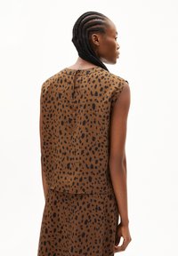 Brown sleeveless top with a black leopard print, featuring a straight cut, round neckline, and a button closure at the back.