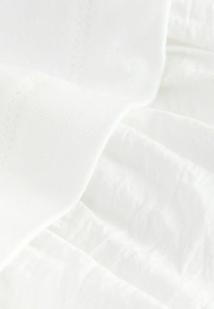 Balta medžiaga su lygiu, minkštu paviršiumi, turinti vos matomus raukšleles ir siūles, kurios dera su medžiaga, pabrėžiant jos lengvą kokybę.