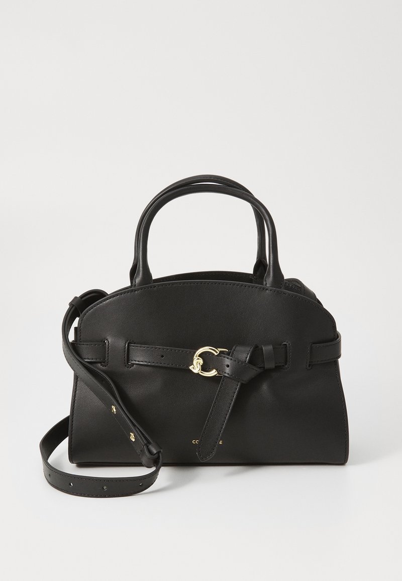 Sac à main en cuir noir avec un dessus arrondi, des doubles poignées et une bandoulière amovible. Il présente un accent en métal doré et un détail en ruban.