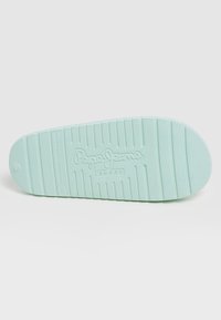 Semelle de chaussure en caoutchouc bleu clair avec une bande de roulement texturée et le logo "Pepe Jeans London" embossé au centre.