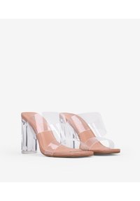 Sandalias con tacón bloque transparente, con plantilla en color nude y dos tiras transparentes sobre el empeine y el dedo gordo. Textura de superficie suave.