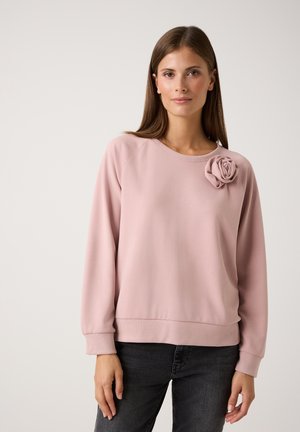 Helles rosa Sweatshirt aus weichem Stoff, mit rundem Halsausschnitt und gerippten Bündchen. Dekorativer Stoffrose-Akzent auf der linken Schulter.