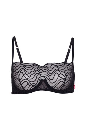 Zwarte doorschijnende kanten beha met beugel en verstelbare dunne bandjes, voorzien van een golvend patroon en een klein rood label aan de zijkant.