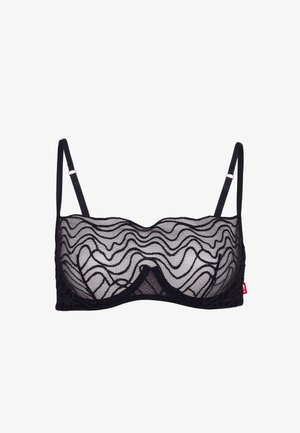Zwarte doorschijnende kanten beha met beugel en verstelbare dunne bandjes, voorzien van een golvend patroon en een klein rood label aan de zijkant.