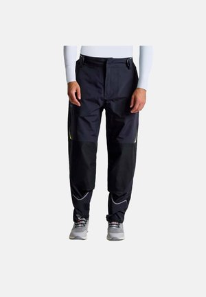 Zwarte waterdichte broek met groene accenten, brede pijpen en twee voorzakken. Het materiaal heeft een gladde, duurzame textuur, geschikt voor buitengebruik.