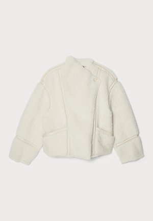 Valkoinen shearling-takki, jossa on korkea kaulus, epäsymmetrinen sulkeminen ja sivutaskut. Ominaisuuksiin kuuluvat näkyvät ompeleet ja pehmeä rakenne.