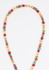 Multicolored beaded necklace featuring irregular, polished stones in red, green, blue, peach, and gold accents, with a seamless design.
