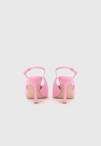 Pink sandale s potpeticom od mekog i dlakavog materijala, otvorene stražnje strane i tanke naramenice. Imaju stiletto potpeticu i bež potplat.