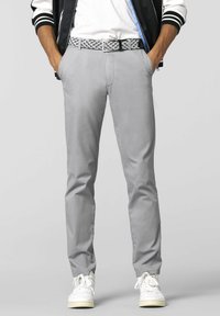 Grijze slim-fit broek van lichtgewicht stof, met een gemusterde riem en witte sneakers. Soepele textuur met een op maat gemaakte stijl.