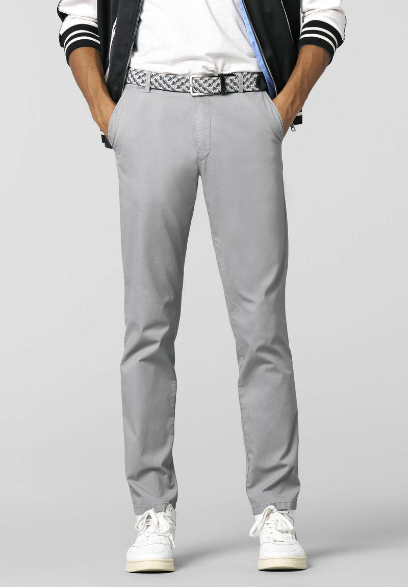 Grijze slim-fit broek van lichtgewicht stof, met een gemusterde riem en witte sneakers. Soepele textuur met een op maat gemaakte stijl.