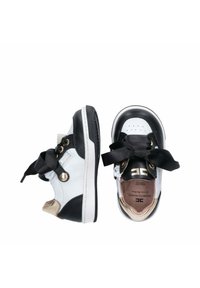 Sneaker in bianco e nero con accenti dorati, pelle texture, punta rotonda, lacci in gros grain neri oversize e etichetta interna visibile.