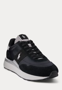 Černé sportovní tenisky ze semiše a syntetického materiálu, s logem, černými tkaničkami, polstrovanou podešví a šedými akcenty.