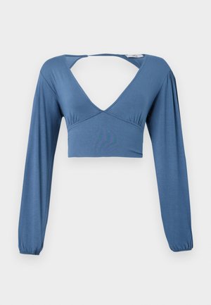 Sininen pitkähihainen crop-top pehmeässä kankaassa, syvällä V-kaula-aukkolla ja avoimella selkädesignilla. Etupuolella kerrosteinen yksityiskohta ja elastiset hihansuut.