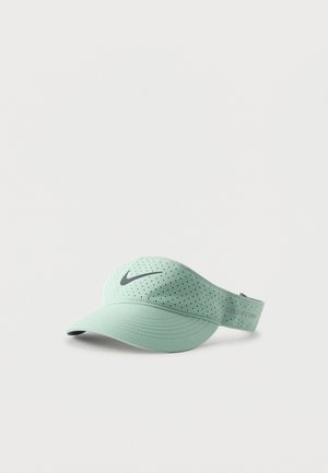 Φωτεινό πράσινο καπέλο Nike Dri-FIT με διάτρητο ύφασμα και μαύρο λογότυπο μπροστά σε μονόχρωμο φόντο.