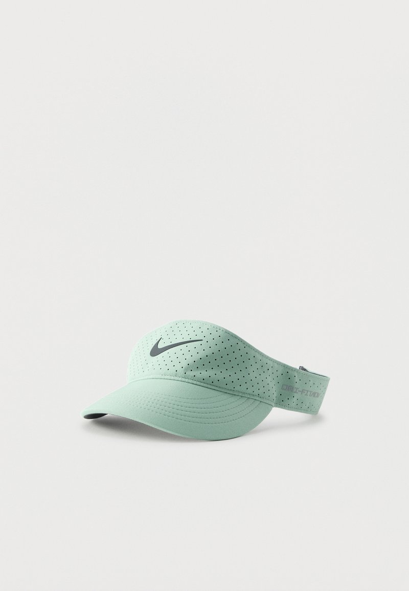 Φωτεινό πράσινο καπέλο Nike Dri-FIT με διάτρητο ύφασμα και μαύρο λογότυπο μπροστά σε μονόχρωμο φόντο.