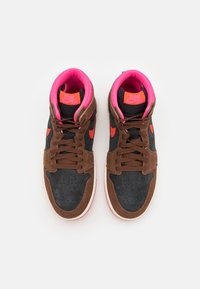 High-top sneakers with a brown suede and black leather upper, pink lining, red accents, and perforated toe box. Features lace-up design.