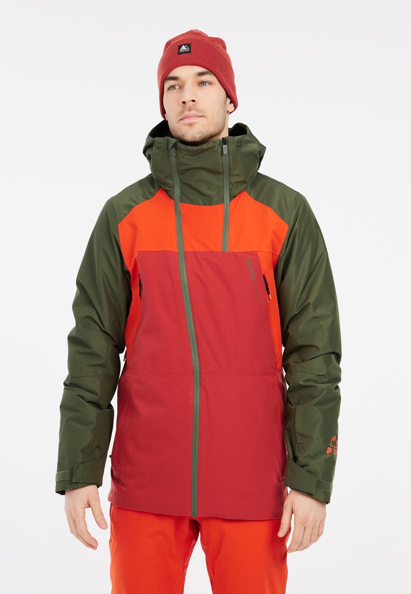Rode en groene geïsoleerde winterjas met een capuchon, voorzien van ritszakken en een bicolor ontwerp. Draagtextiel is een oranje beanie.