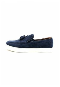 Chaussure slip-on en daim bleu marine avec une semelle en caoutchouc blanc, dotée d'un gland décoratif à l'avant et d'un doublure intérieure lisse.