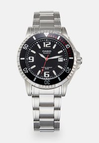 Casio quartz wristwatch with a black face, silver stainless steel band, large white and red numerals, and a water-resistant feature up to 200m.