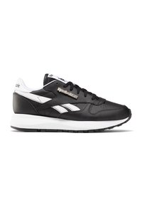 Czarne skórzane sneakersy z białymi akcentami, posiadające wyściełany kołnierz, perforowaną część przednią oraz teksturowaną gumową podeszwę. Logo Reebok jest metaliczne.