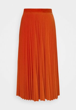 Longue jupe plissée orange vif avec une taille haute et un petit détail de logo métallique sur la partie supérieure.