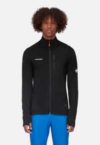 Black zip-up jacket with a textured pattern, high collar, and orange zipper pull. Features a left chest pocket and logo on sleeve.