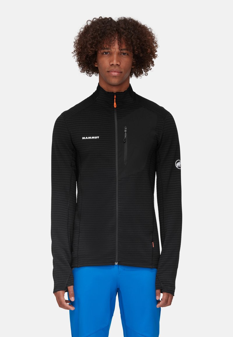 Zwarte zip-up jas met een gestructureerd patroon, hoge kraag en oranje ritsdop. Beschikt over een borstzak aan de linkerkant en een logo op de mouw.