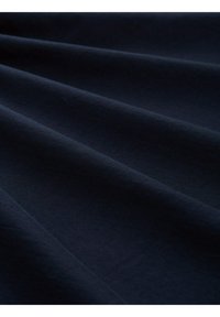 Tmavě modrá látka se hladkou texturou, s viditelnými záhyby a jemným leskem. Materiál vypadá lehce a pružně.