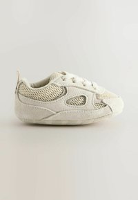 Sneaker pour tout-petit beige clair avec une tige en daim et en maille, fermeture à lacets et petite languette au niveau du talon. Bout arrondi et semelle extérieure texturée.