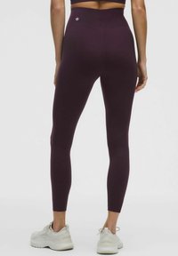 Aukštu liemeniu, formą atitinkančios tamprės tamsiai burgundiškos spalvos, pagamintos iš tamprios medžiagos, su logotipu nugaros juosmens srityje.