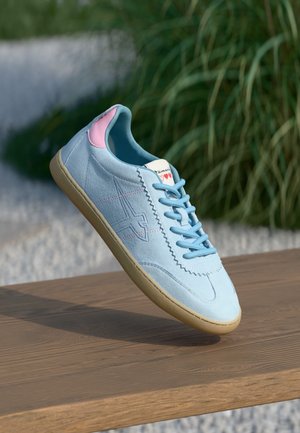Hellblaues Wildleder-Sneaker mit rosa Akzenten, flachen Schnürsenkeln und einer strukturierten Gummisohle. Mit geprägt Design und Branding auf der Zunge.