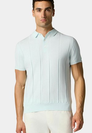 Lichtblauw gebreid poloshirt met korte mouwen, geribbelde structuur, knopen bij de kraag, en verticale panelen. Lichtgewicht stof.